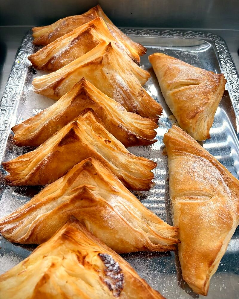 Triunghiuri de foietaj proaspăt coapte, pe tavă
