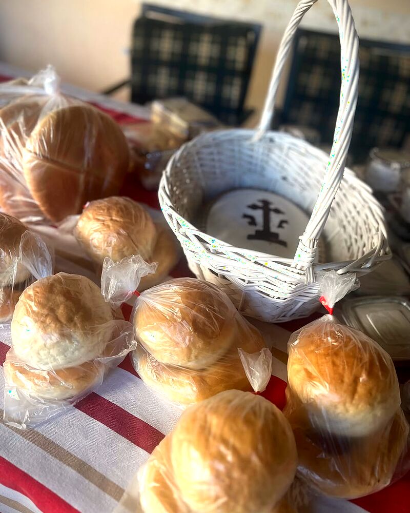Colivă în coșuleț de nuiele, alături de chifle și pâine împletită pentru pomenire