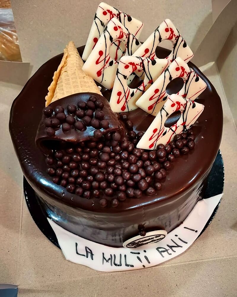 Tort cu glazură de ciocolată neagră, perle de ciocolată și napolitane decorative
